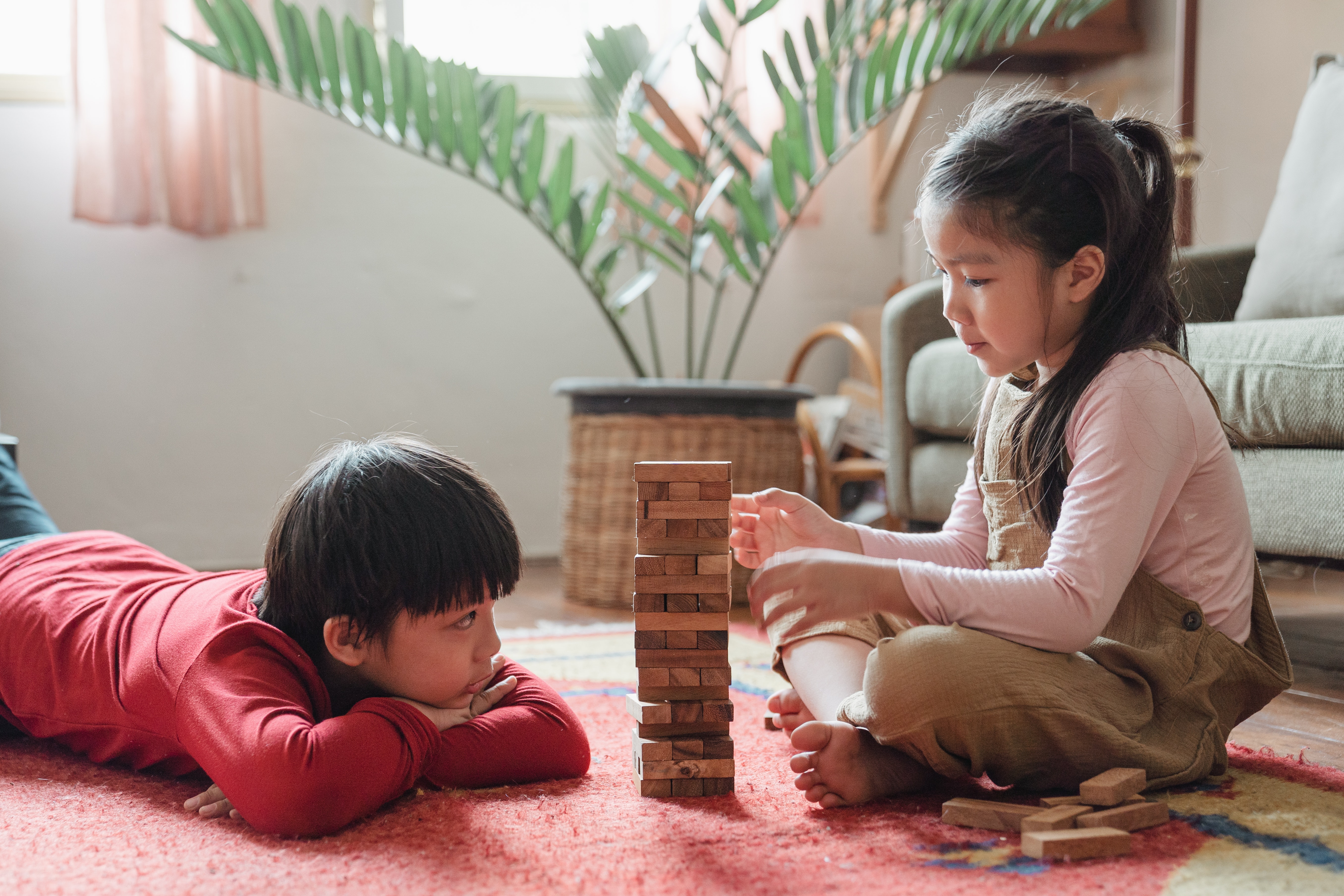 Two children playing on the floor with blocks